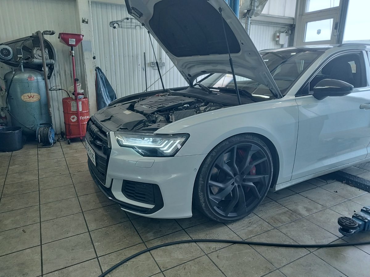 Geöffneter Motorraum eines Audi in der Halle von Car Care Krems