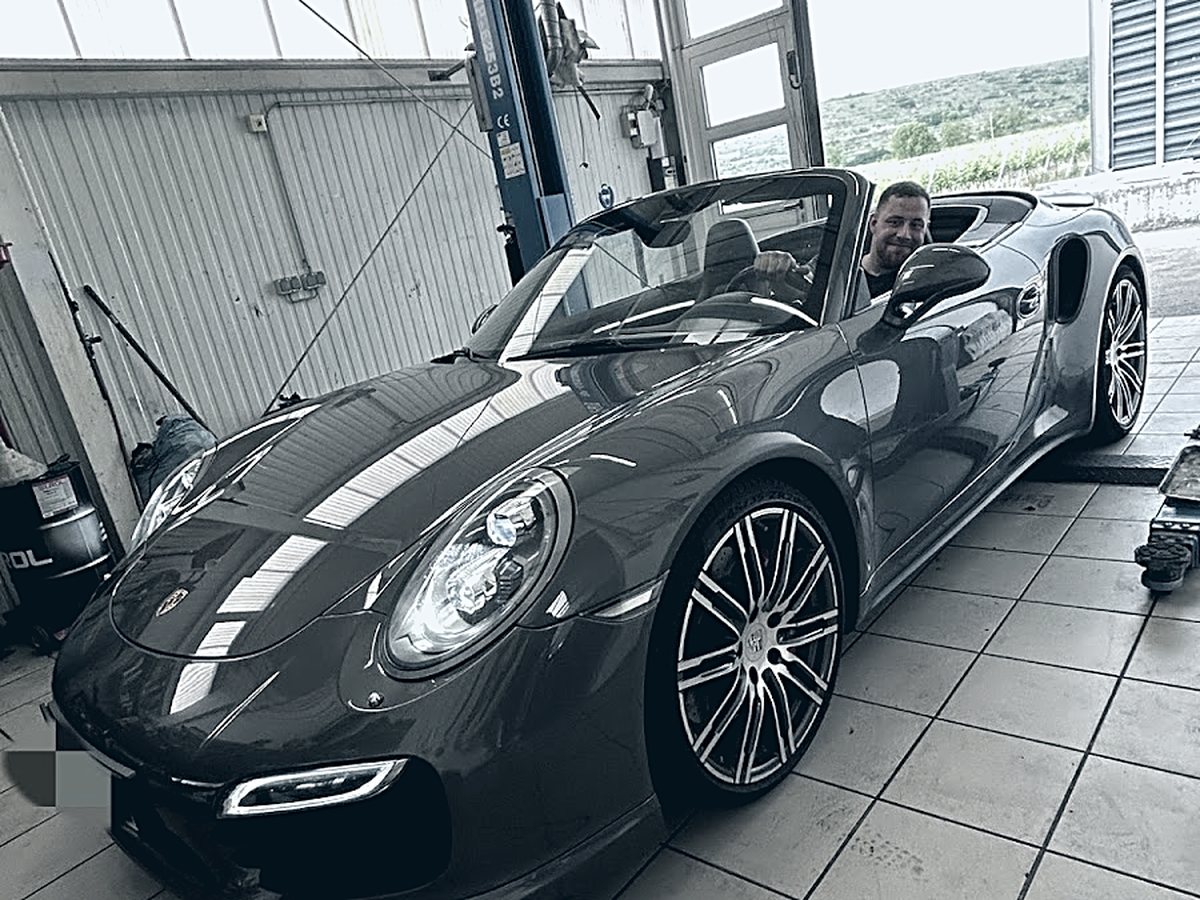 Blick in die Halle von Car Care Krems durch das offene Tor, ein Porsche im Innenraum